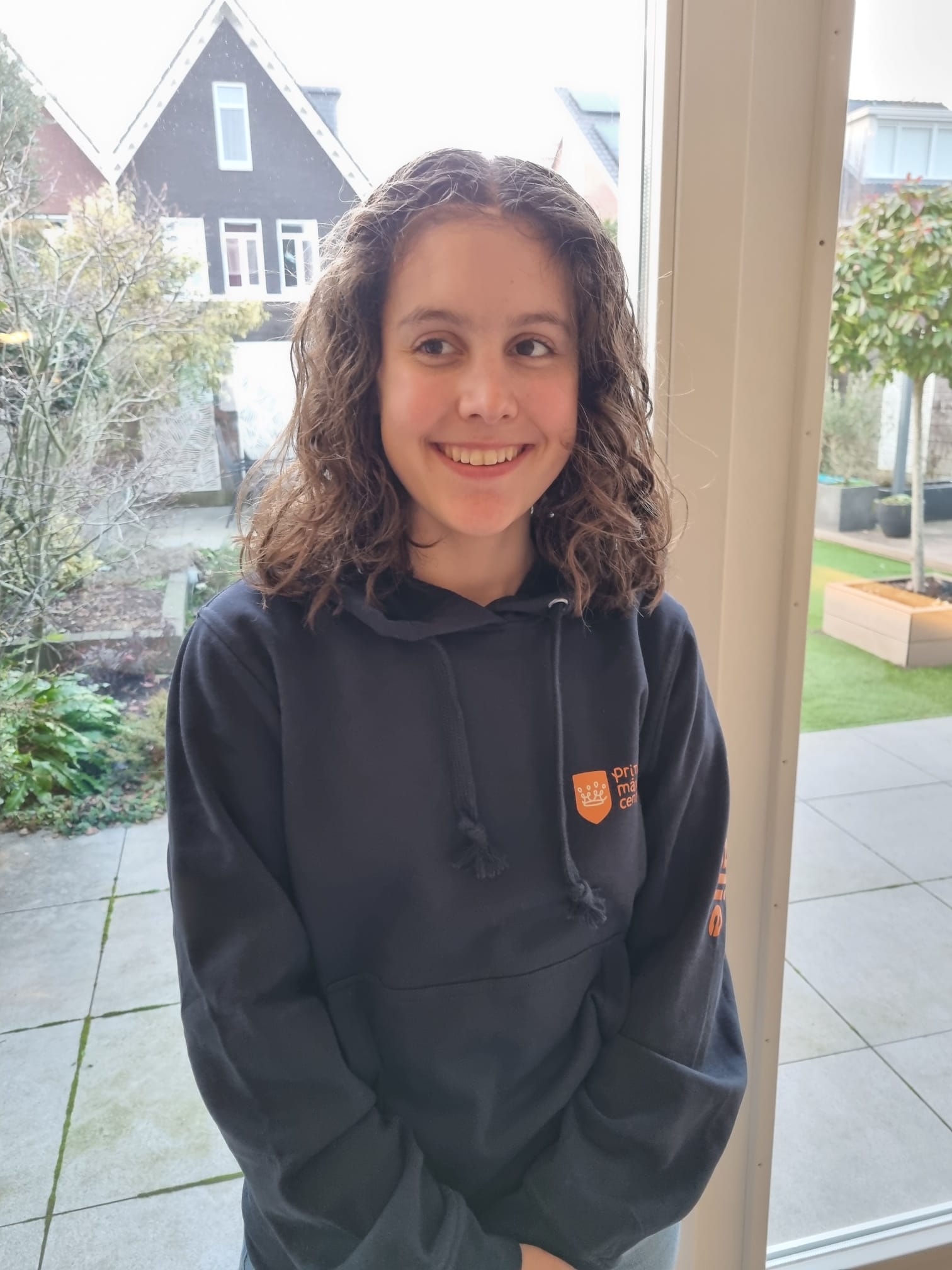 Emelie staat lachend op de foto in haar eigen huis