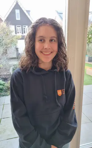 Emelie staat lachend op de foto in haar eigen huis Emelie staat lachend op de foto in haar eigen huis