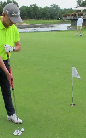 Ronald Boef staat op de golfbaan. Hij heeft een fel geel shirt aan en staat klaar om de golfbal in de hole te tikken. Ronald Boef staat op de golfbaan. Hij heeft een fel geel shirt aan en staat klaar om de golfbal in de hole te tikken.