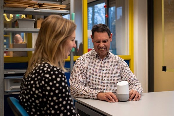 Man en begeleidster gebruiken Google Home