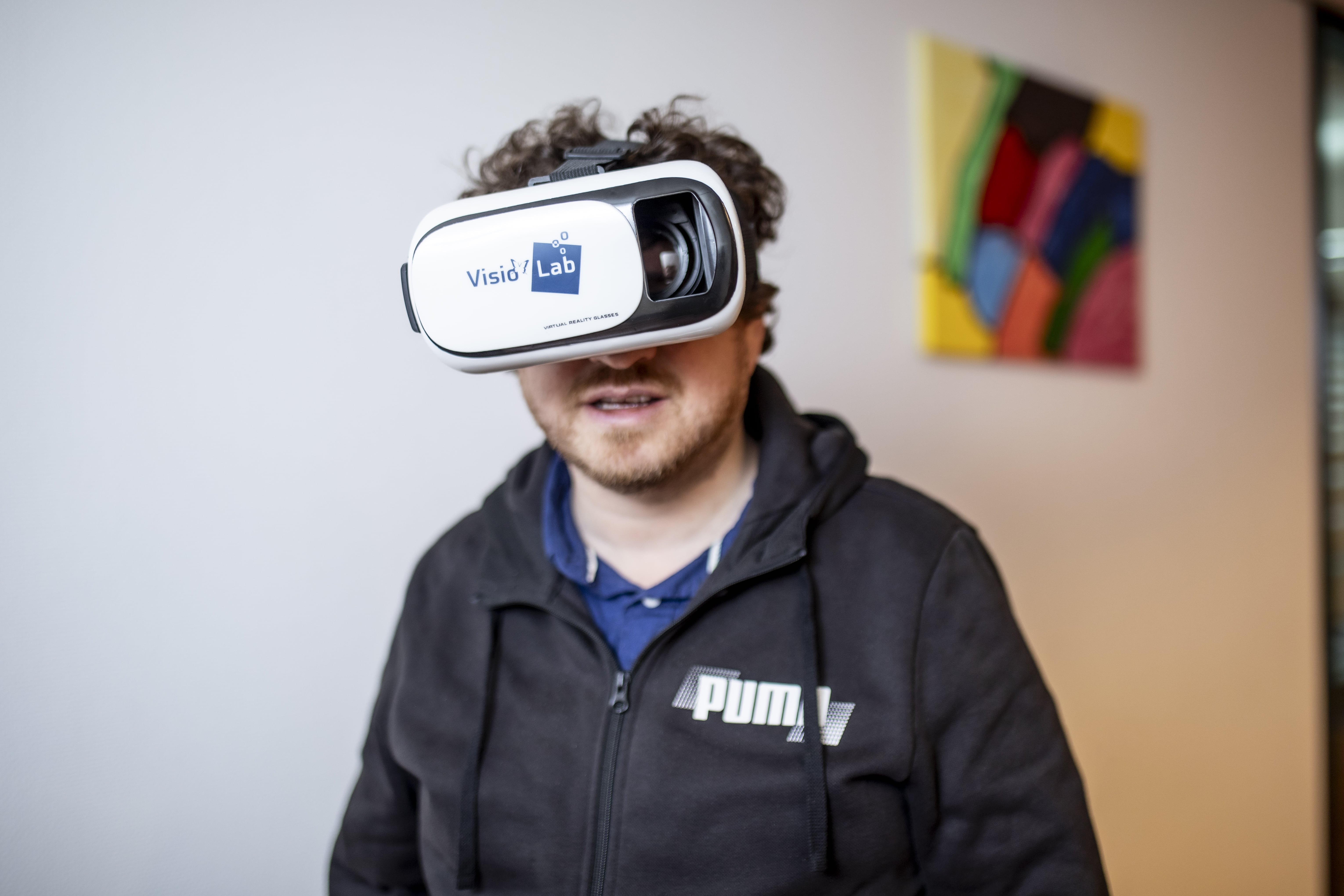 Een man draagt een VR bril met VisioLab erop.