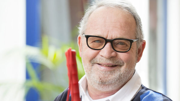 Oudere man met glaucoom glimlacht zittend met een taststok in zijn hand Oudere man met glaucoom glimlacht zittend met een taststok in zijn hand