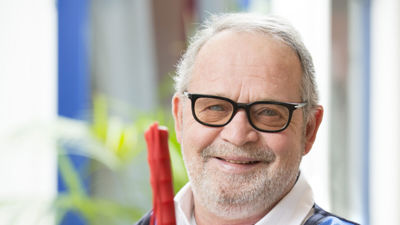 Oudere man met glaucoom glimlacht zittend met een taststok in zijn hand Oudere man met glaucoom glimlacht zittend met een taststok in zijn hand