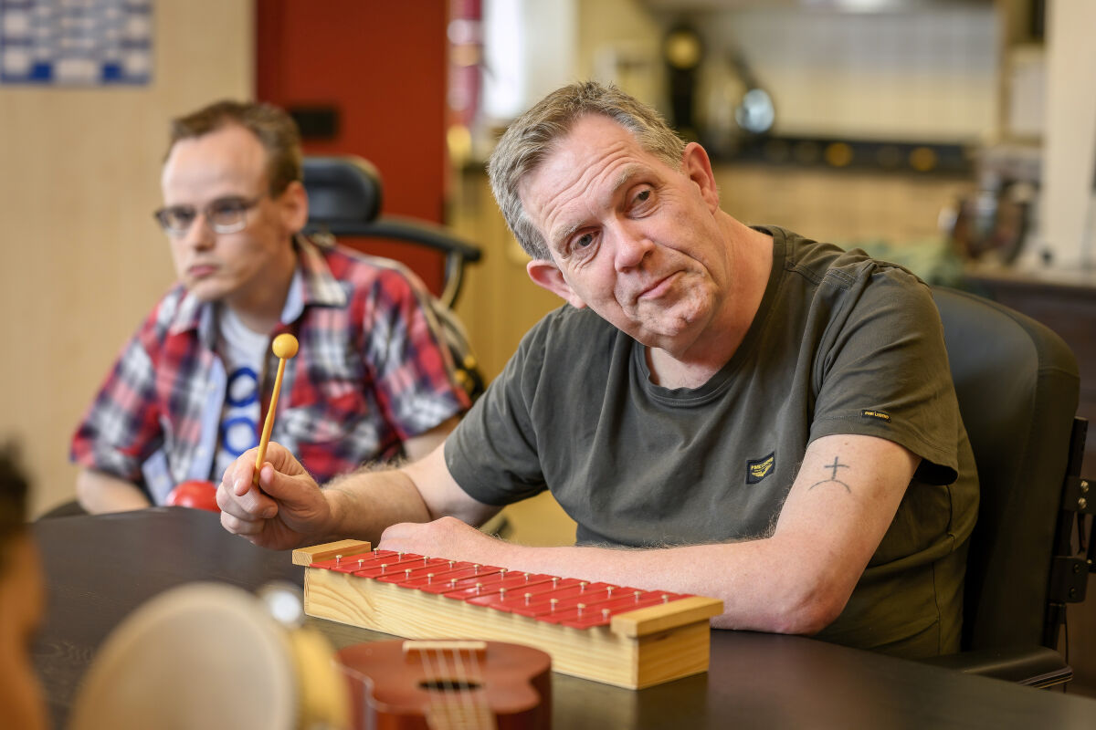 Cliënt met een visuele en verstandelijke beperking speelt op een xylofoon