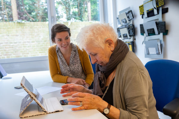 Oudere dame krijgt ICT-advies op iPad bij Visio