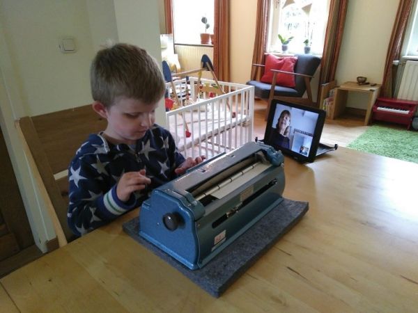 Jongetje achter braille-typemachine Jongetje achter braille-typemachine