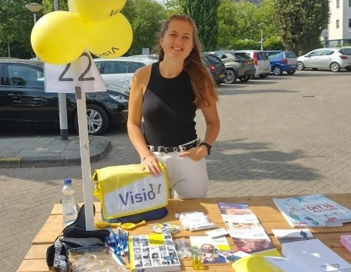 Vera Bouman, jobcoach en maatschappelijk werker achter een Visio-stand Vera Bouman, jobcoach en maatschappelijk werker achter een Visio-stand