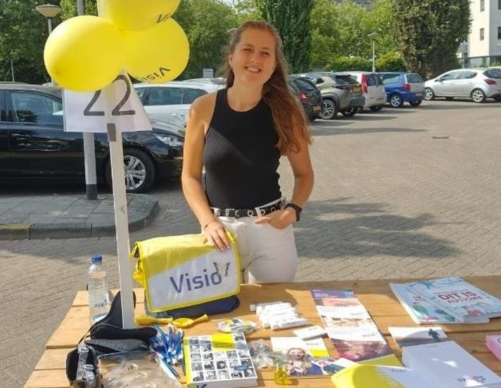 Vera Bouman, jobcoach en maatschappelijk werker achter een Visio-stand