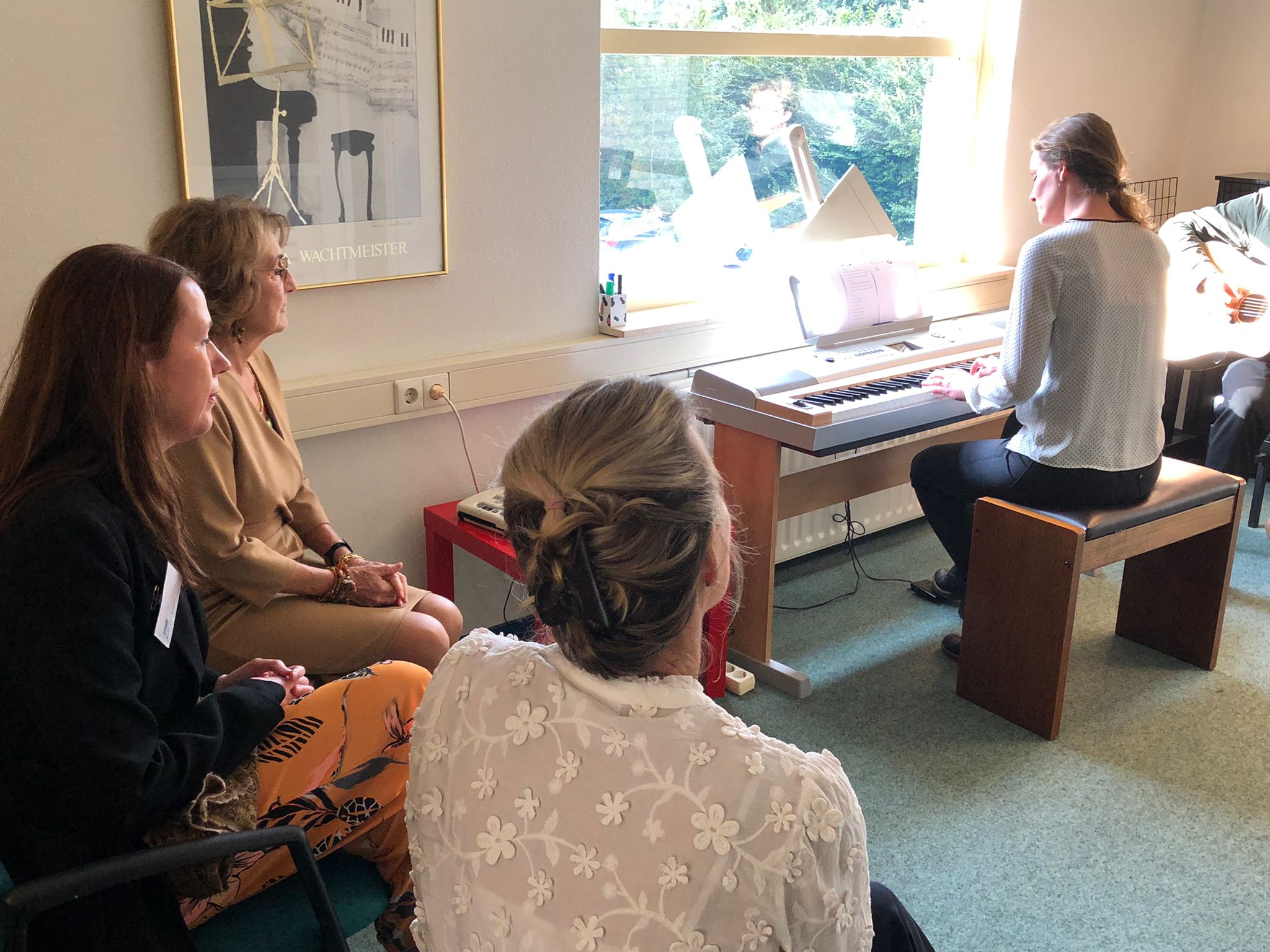 Bezoek HMH Margriet aan Visio Het Loo Erf: vrouw speelt piano