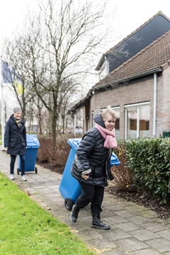 Cliënt Marijke en begeleider zetten de kliko's weg in Emmen Cliënt Marijke en begeleider zetten de kliko's weg in Emmen