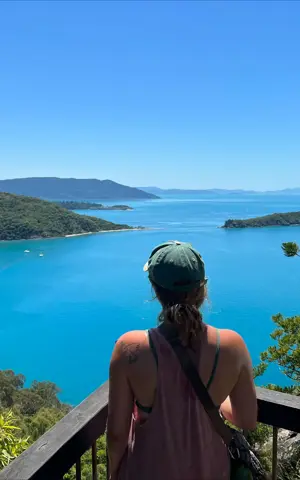 Hanna staat met haar rug naar de camera. Ze kijkt uit over een blauw meer. Hanna staat met haar rug naar de camera. Ze kijkt uit over een blauw meer.