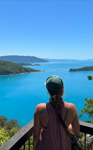 Hanna staat met haar rug naar de camera. Ze kijkt uit over een blauw meer. Hanna staat met haar rug naar de camera. Ze kijkt uit over een blauw meer.