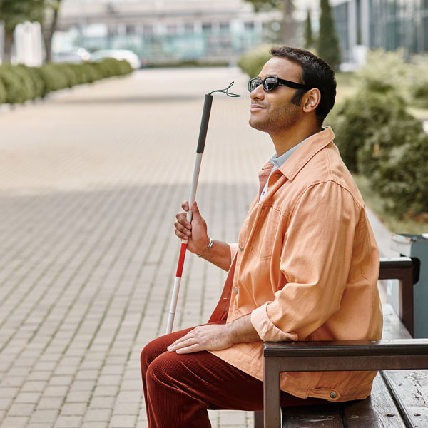 Blinde man met taststok op de bank Blinde man met taststok op de bank